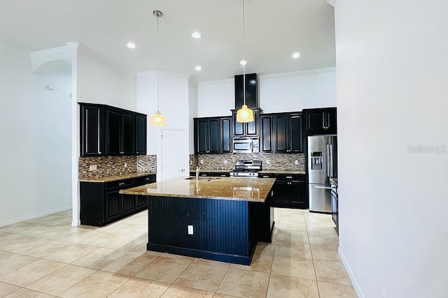 kitchen featuring light stone counters, an island with sink, a sink, stainless steel appliances, and dark cabinets