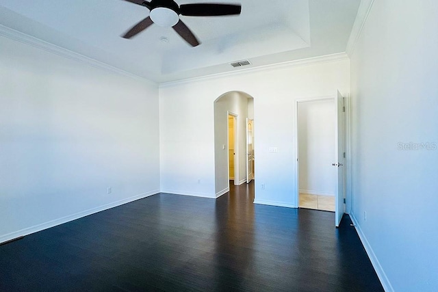 empty room featuring visible vents, ornamental molding, arched walkways, a raised ceiling, and ceiling fan