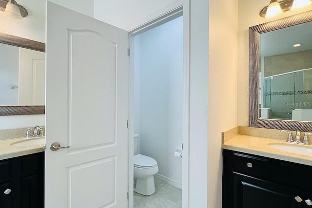 bathroom with baseboards, toilet, a stall shower, and vanity