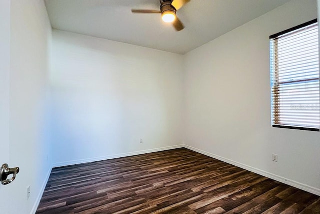 spare room with dark wood-style floors, baseboards, and a ceiling fan