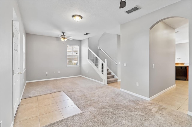 carpeted empty room featuring ceiling fan and a textured ceiling