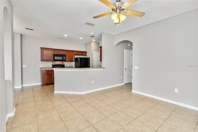 kitchen featuring light tile patterned floors, kitchen peninsula, ceiling fan, and black appliances