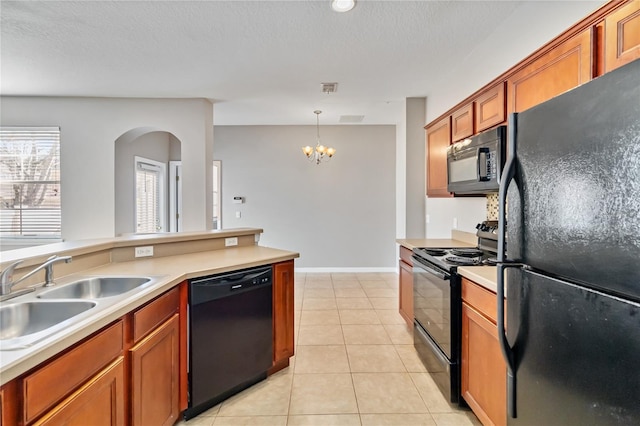 kitchen featuring sink, hanging light fixtures, light tile patterned floors, black appliances, and a textured ceiling