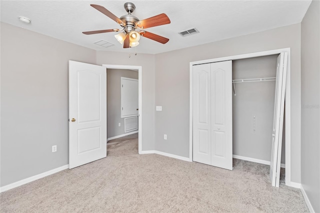 unfurnished bedroom with light colored carpet, a closet, and ceiling fan