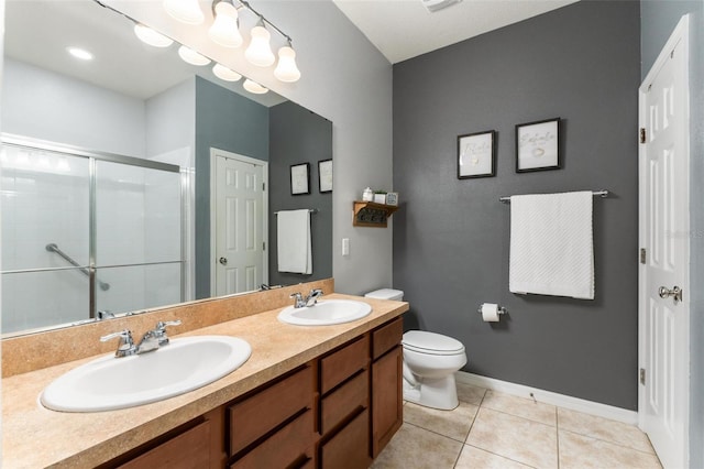 bathroom with tile patterned floors, vanity, toilet, and a shower with shower door