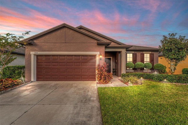 single story home featuring a garage and a yard