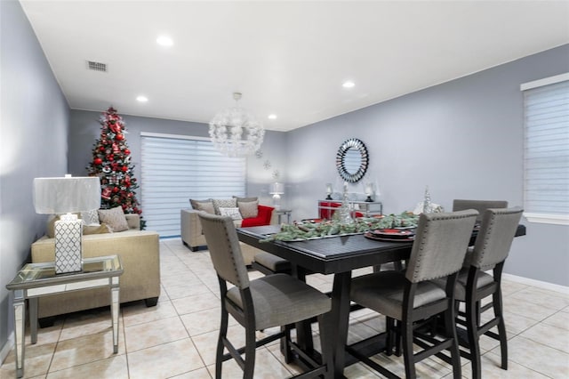 dining area with a notable chandelier and light tile patterned floors