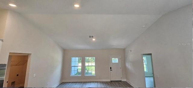 doorway to outside featuring lofted ceiling and hardwood / wood-style flooring