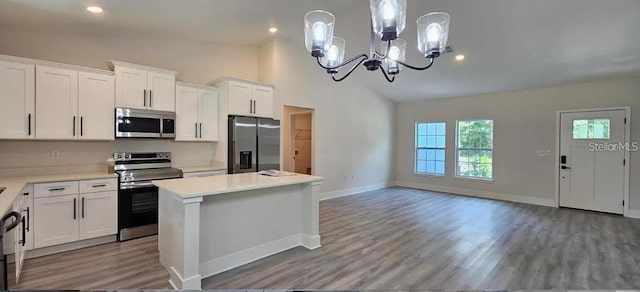 kitchen with a center island, stainless steel appliances, a notable chandelier, pendant lighting, and white cabinets