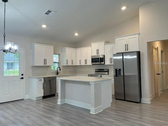 kitchen with sink, hanging light fixtures, a chandelier, white cabinets, and appliances with stainless steel finishes