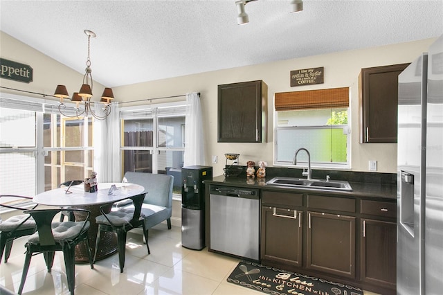 kitchen featuring dark brown cabinetry, sink, stainless steel appliances, vaulted ceiling, and light tile patterned floors