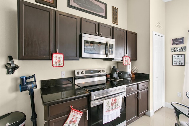 kitchen featuring light tile patterned floors, dark brown cabinetry, and stainless steel appliances