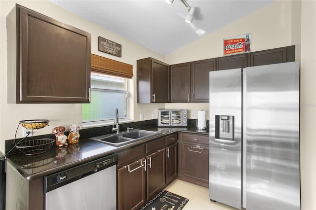 kitchen featuring a textured ceiling, lofted ceiling, sink, and appliances with stainless steel finishes