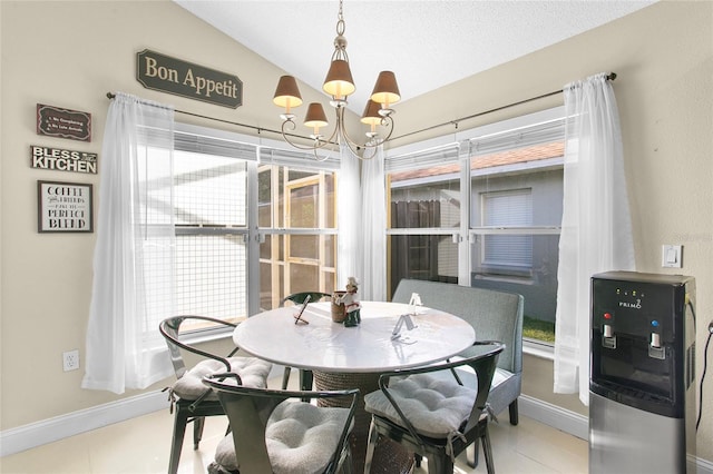 tiled dining room with a chandelier and vaulted ceiling