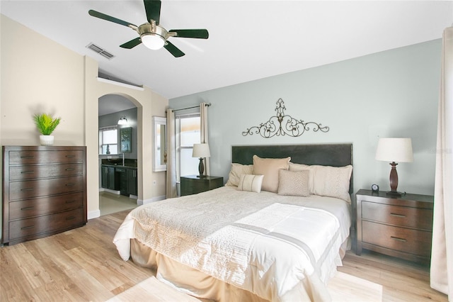 bedroom with connected bathroom, light hardwood / wood-style flooring, ceiling fan, and lofted ceiling