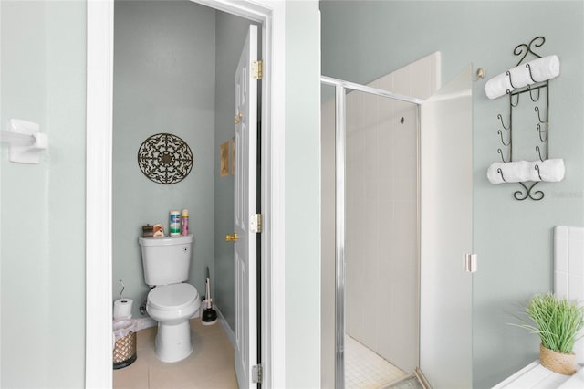 bathroom with tile patterned floors, toilet, and a shower with shower door