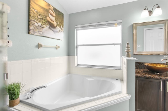 bathroom with vanity and a relaxing tiled tub