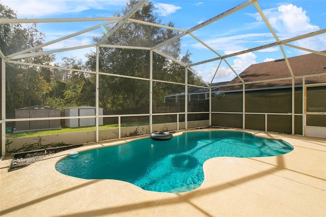 view of swimming pool with glass enclosure, a patio area, and a storage shed