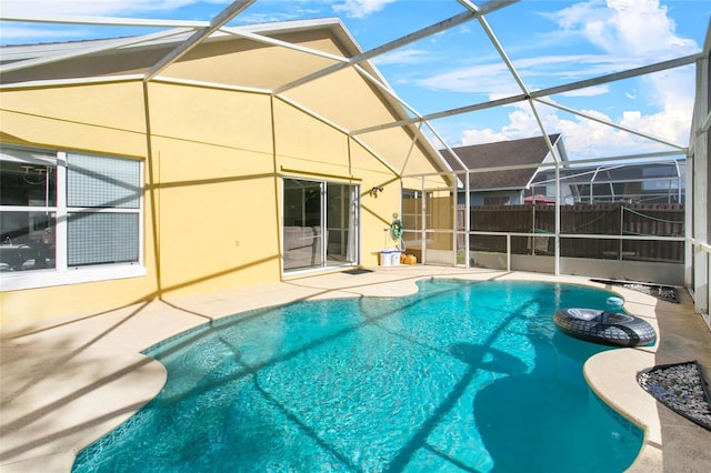 view of swimming pool with glass enclosure and a patio area