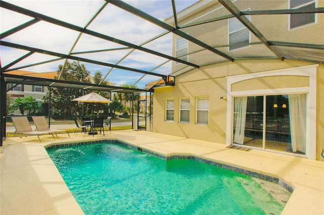 view of swimming pool with glass enclosure and a patio