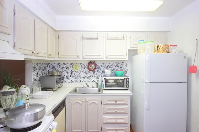 kitchen featuring dishwasher, sink, white fridge, decorative backsplash, and white cabinets