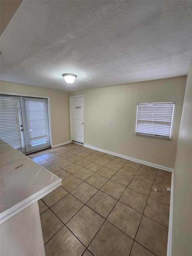 interior space with tile patterned flooring, a textured ceiling, and a wealth of natural light