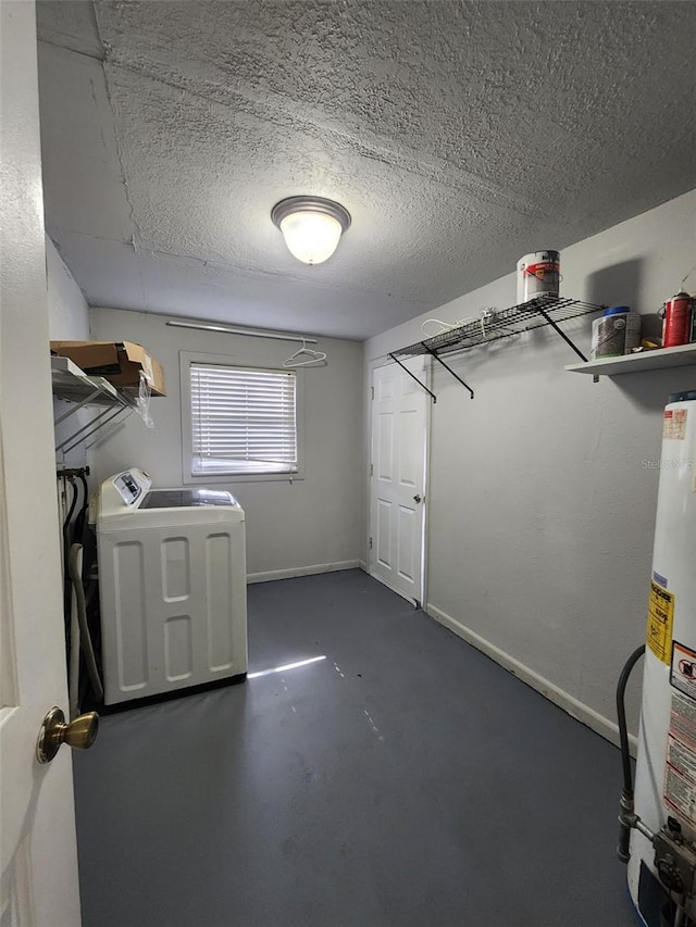 clothes washing area featuring a textured ceiling, washer / clothes dryer, and water heater