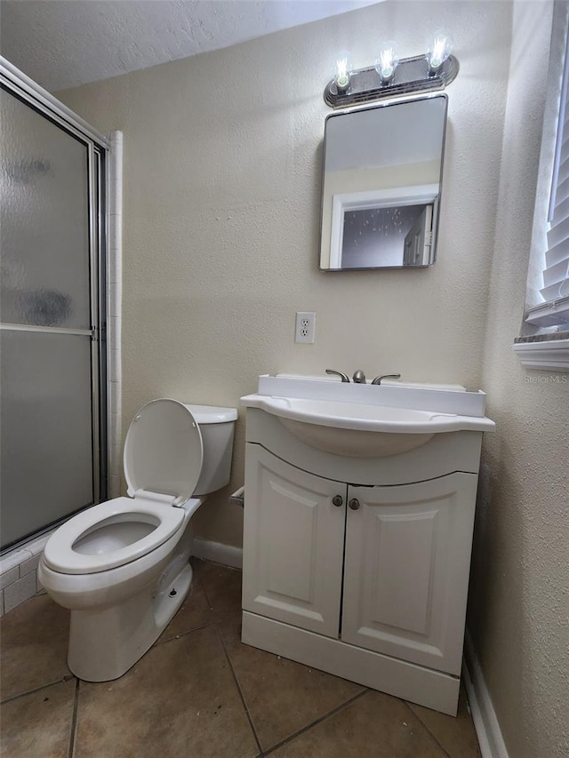 bathroom featuring tile patterned floors, walk in shower, vanity, and toilet