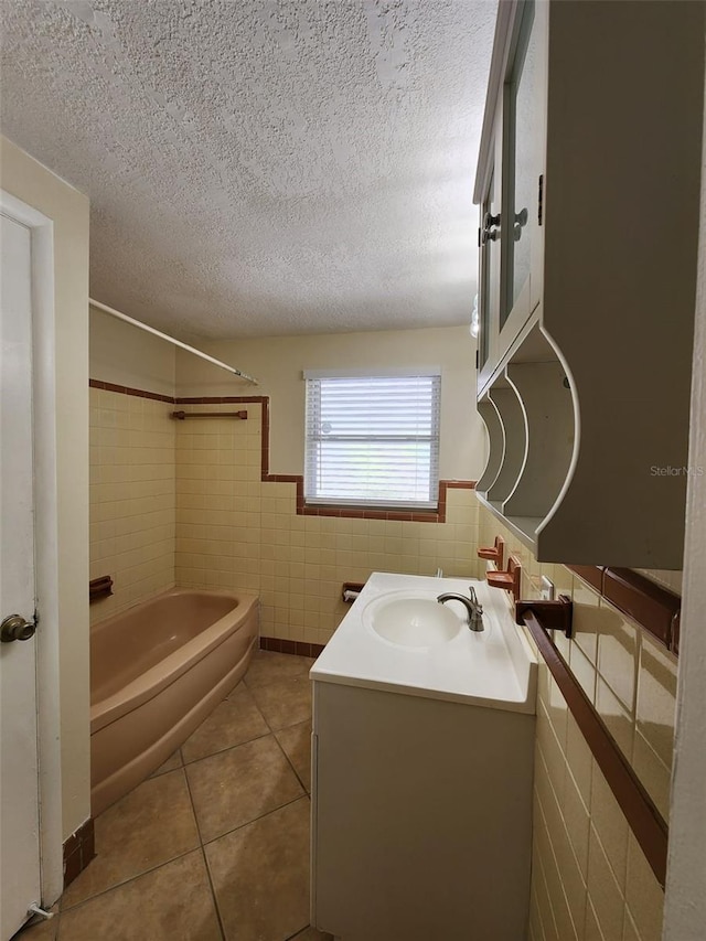 bathroom featuring tile patterned flooring, a textured ceiling, shower / tub combination, vanity, and tile walls