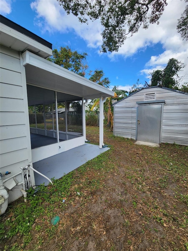 view of yard with a storage unit and a sunroom