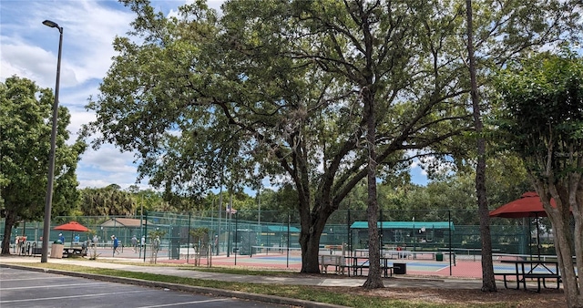 view of community featuring tennis court