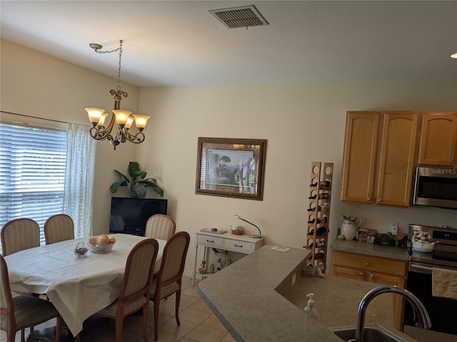 tiled dining space featuring sink and an inviting chandelier