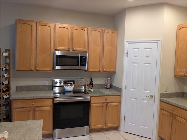 kitchen featuring light tile patterned floors and appliances with stainless steel finishes