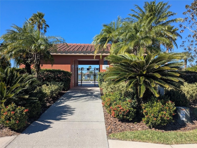 753 Largo Pass, Poinciana, FL 34759 - view of front facade featuring a tile roof, driveway, a gate, and stucco siding