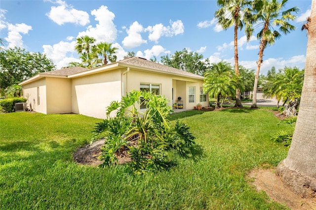 753 Largo Pass, Poinciana, FL 34759 - rear view of house featuring a lawn, stucco siding, and cooling unit
