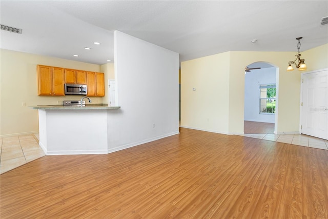 753 Largo Pass, Poinciana, FL 34759 - unfurnished living room with arched walkways, baseboards, visible vents, and light wood-style floors