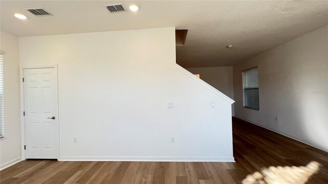 empty room featuring dark wood-type flooring and a textured ceiling