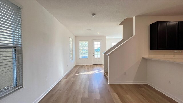 entryway featuring a textured ceiling and light hardwood / wood-style flooring