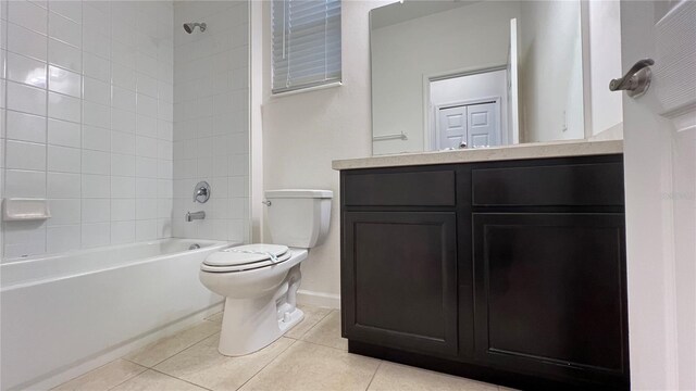 full bathroom featuring tile patterned floors, tiled shower / bath combo, toilet, and vanity