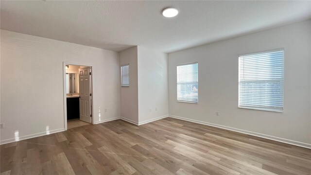 empty room featuring hardwood / wood-style flooring and a textured ceiling