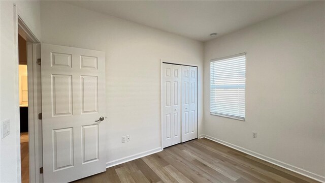 unfurnished bedroom featuring a closet and light wood-type flooring