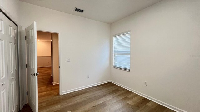 unfurnished bedroom featuring a closet and hardwood / wood-style floors