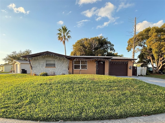 single story home featuring a garage and a front lawn