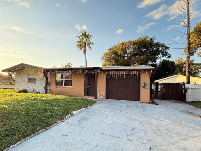 ranch-style home featuring a garage and a front lawn