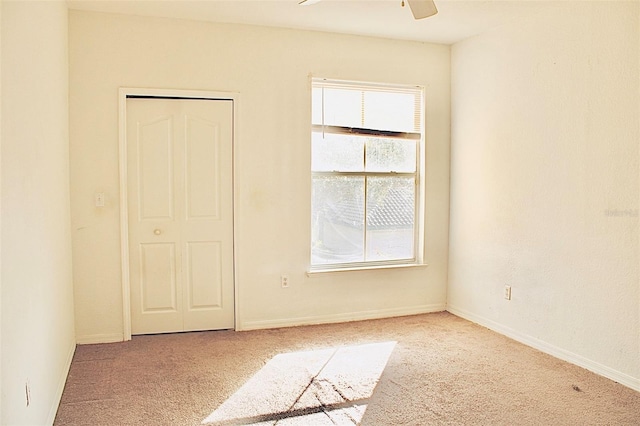 unfurnished bedroom with ceiling fan, a closet, carpet floors, and multiple windows