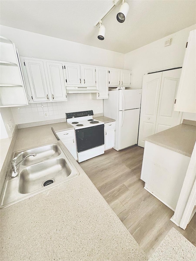 kitchen featuring white appliances, white cabinets, sink, light hardwood / wood-style flooring, and tasteful backsplash