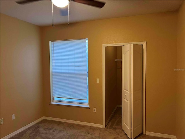 unfurnished bedroom featuring carpet flooring, baseboards, a closet, and ceiling fan