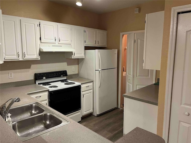 kitchen with under cabinet range hood, a sink, range with electric stovetop, white cabinetry, and freestanding refrigerator