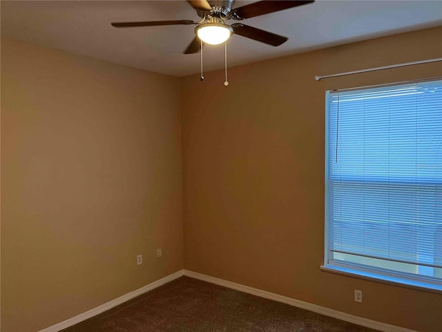 empty room with baseboards, plenty of natural light, and ceiling fan