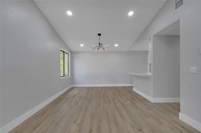 empty room featuring ceiling fan, lofted ceiling, and light wood-type flooring